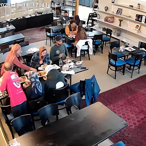 Diners enjoying Afghan cuisine at tables in a restaurant with shelves displaying decorative items.
