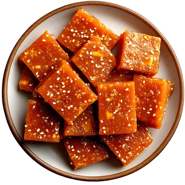 Close-up of Afghan halwa, a sweet dessert, cut into squares and topped with sesame seeds.